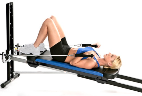 A women lies on her back using a Total Gym XLS exercise machine